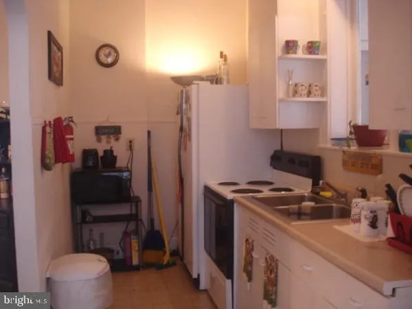 a kitchen with a refrigerator and a stove top oven