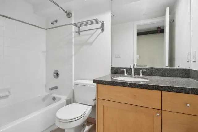 a bathroom with a granite countertop sink toilet and shower