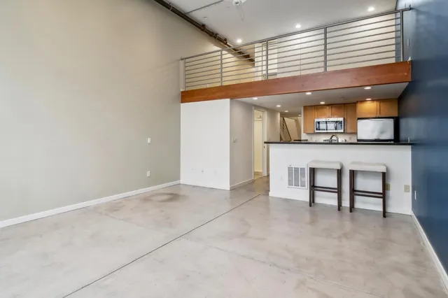 an empty room with a kitchen view and a window