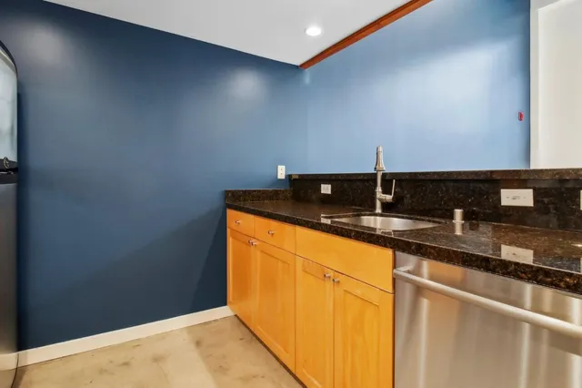 a kitchen with granite countertop a sink and cabinets