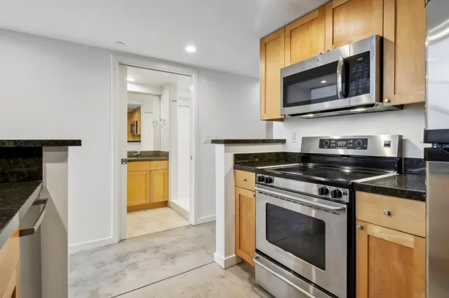 a kitchen with stainless steel appliances granite countertop a stove microwave and sink
