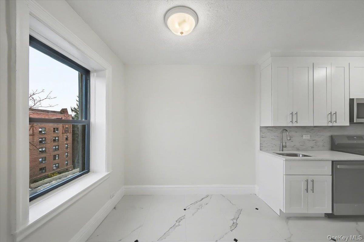 127 Garth Road, Unit 5D Scarsdale, NY 10583 - Photo 11 of 20 a view of cabinets a sink and a window in a room