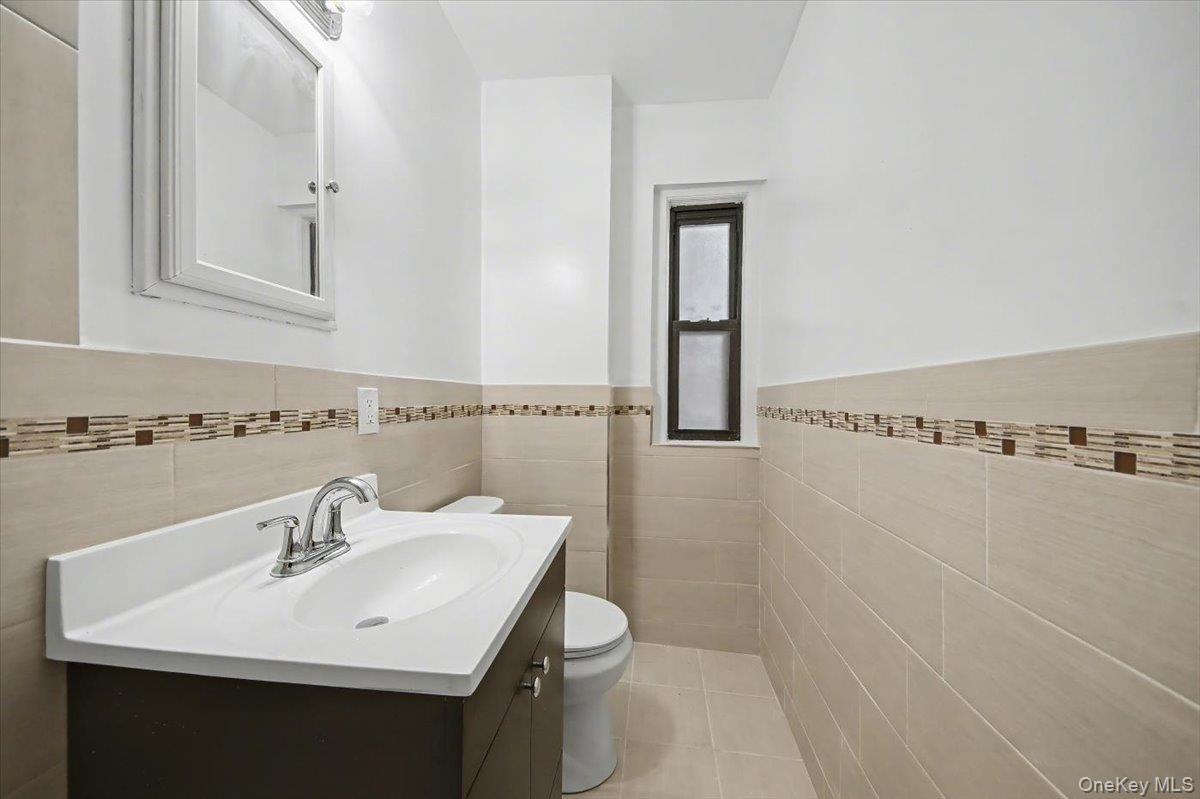 127 Garth Road, Unit 5D Scarsdale, NY 10583 - Photo 15 of 20 a bathroom with a sink a toilet and mirror