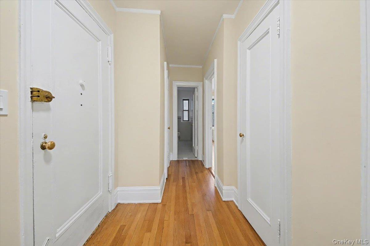127 Garth Road, Unit 5D Scarsdale, NY 10583 - Photo 17 of 20 a view of a hallway with wooden floor and staircase