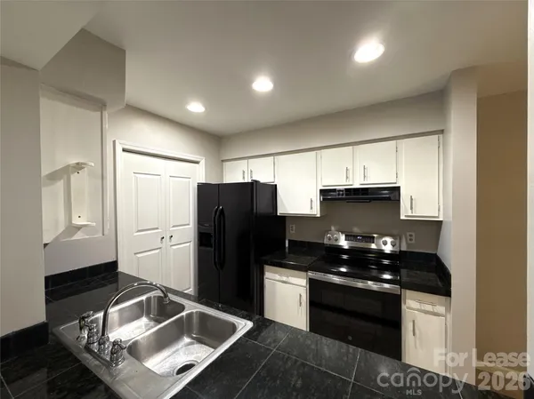 a kitchen with stainless steel appliances granite countertop a refrigerator and a sink