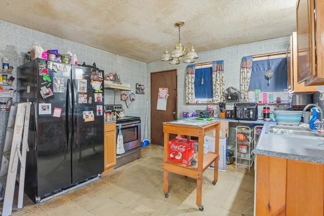 a kitchen with stainless steel appliances granite countertop a refrigerator and a sink