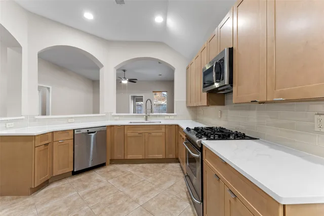 a kitchen with stainless steel appliances granite countertop a stove a sink and a microwave