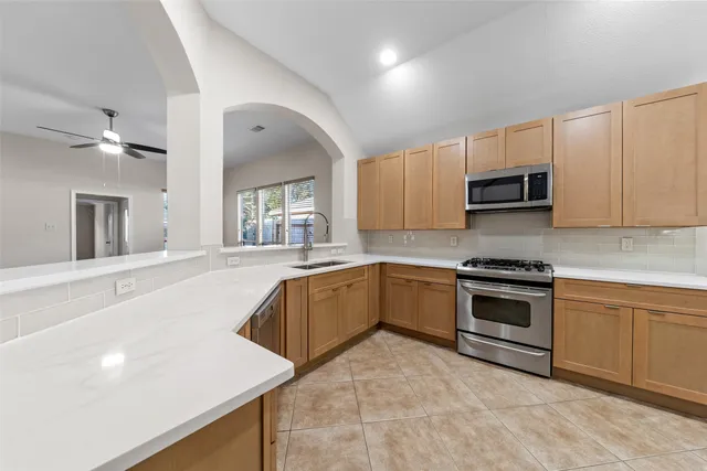 a kitchen with stainless steel appliances granite countertop a stove a sink and a microwave
