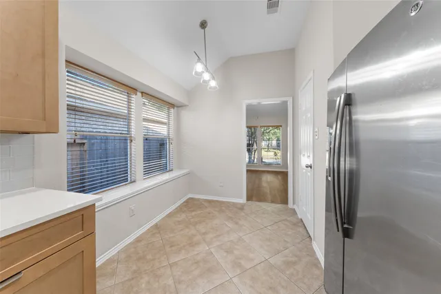 a view of an empty room with window and cabinet