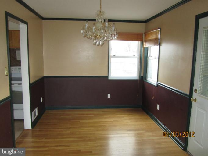 5803 Channing Road Springfield, VA 22150 - Photo 3 of 12 a view of an empty room with window and chandelier fan