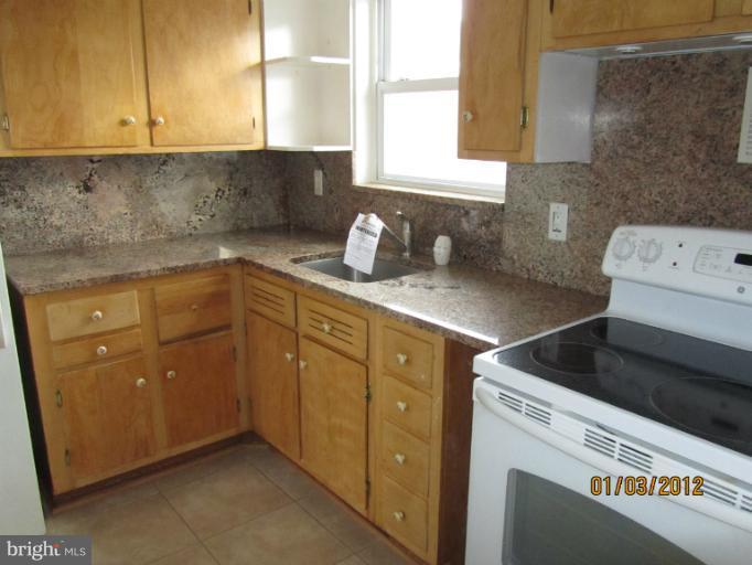 5803 Channing Road Springfield, VA 22150 - Photo 10 of 12 a kitchen with a sink cabinets and a stove top oven