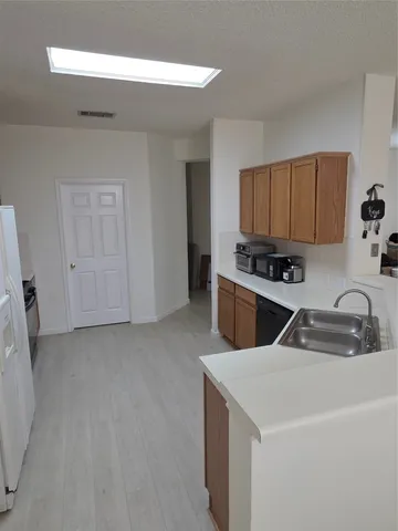 a kitchen with a refrigerator sink and cabinets