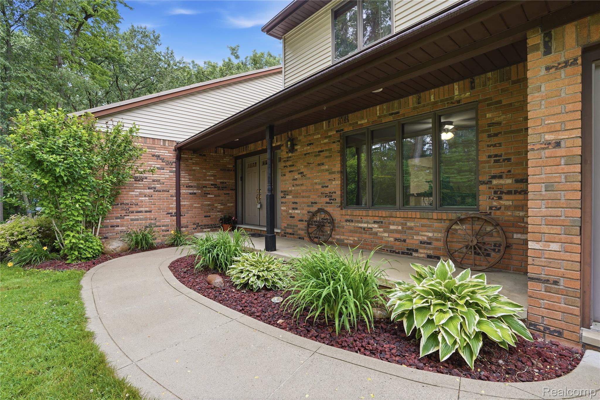 68345 Romeo Plank Road Ray, MI 48096 - Photo 2 of 52 Brick exterior with an expansive covered porch, large windows, and a concrete walkway