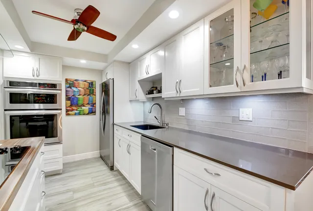 a kitchen with stainless steel appliances granite countertop a sink and a stove