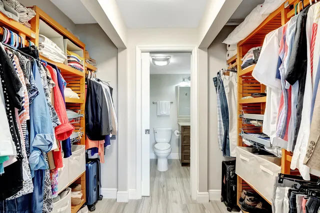 a view of walk in closet with clothes and shoes