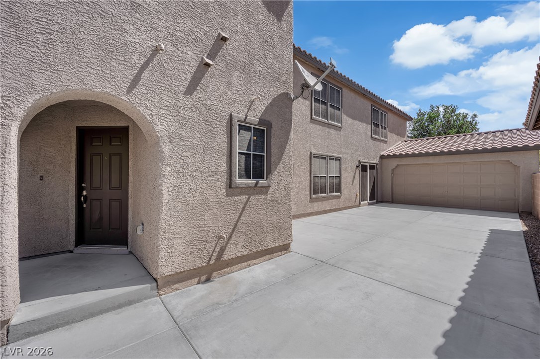 646 Monument Point Street Henderson, NV 89002 - Photo 2 of 44 An inviting arched entryway leads to a well-maintained property with an attached garage.