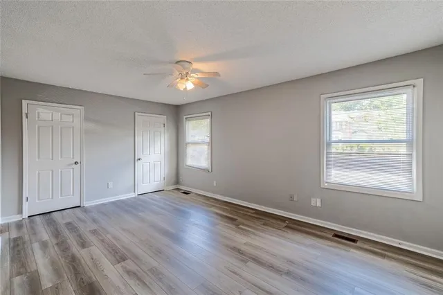 an empty room with wooden floor and window