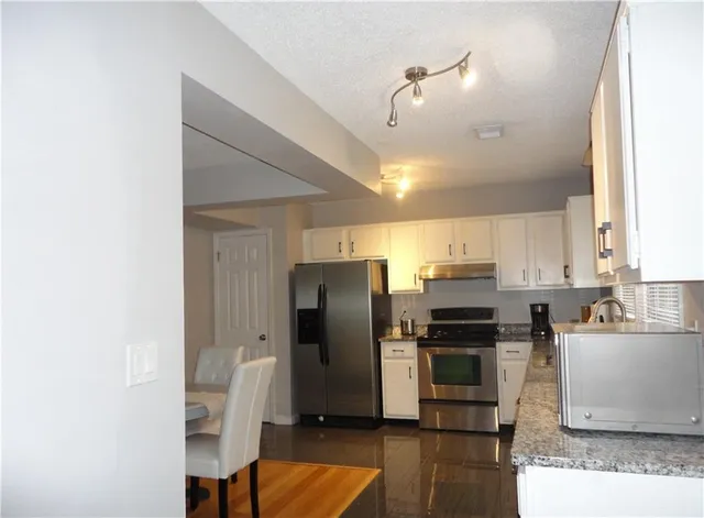 a kitchen with stainless steel appliances a refrigerator and a stove top oven