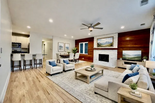 a living room with furniture a flat screen tv and a fireplace