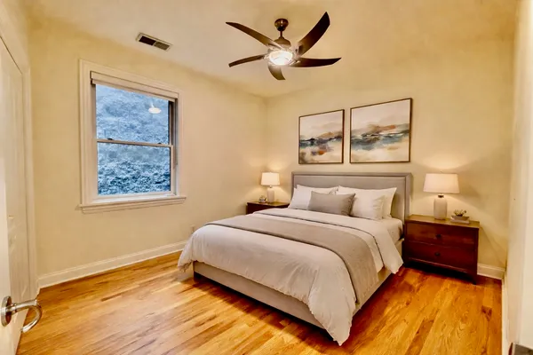 a bedroom with a bed and painting on the wall