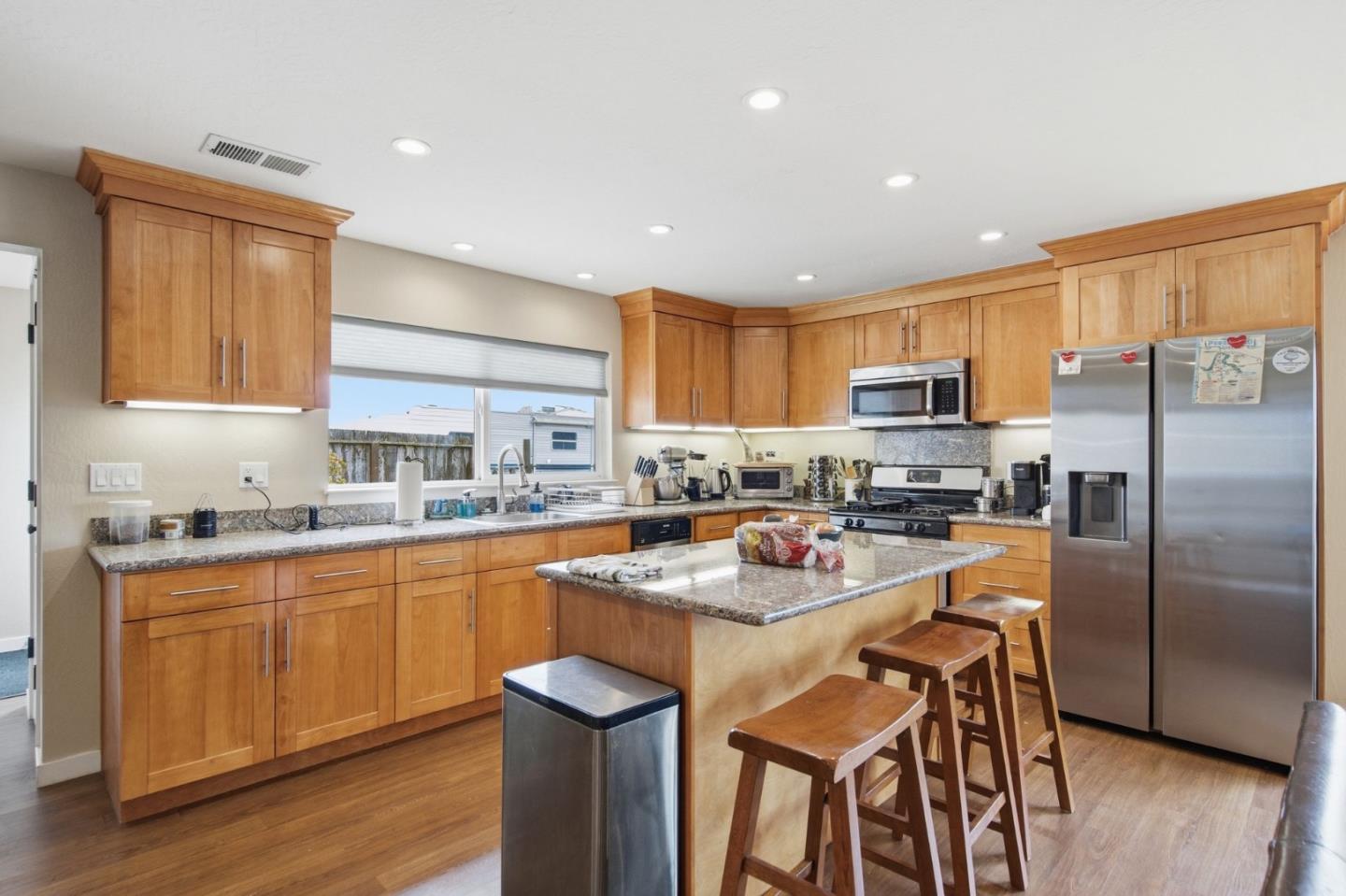 1263 Reservoir Road Pescadero, CA 94060 - Photo 51 of 66 a kitchen with stainless steel appliances granite countertop a stove top oven a sink dishwasher a refrigerator and a dining table with wooden cabinet