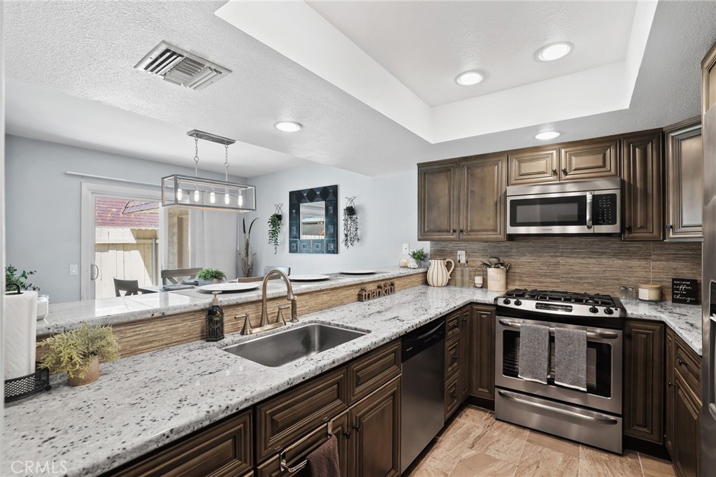 916 Ardmore Circle Redlands, CA 92374 - Photo 1 of 29 a kitchen with stainless steel appliances granite countertop a sink and stove top oven