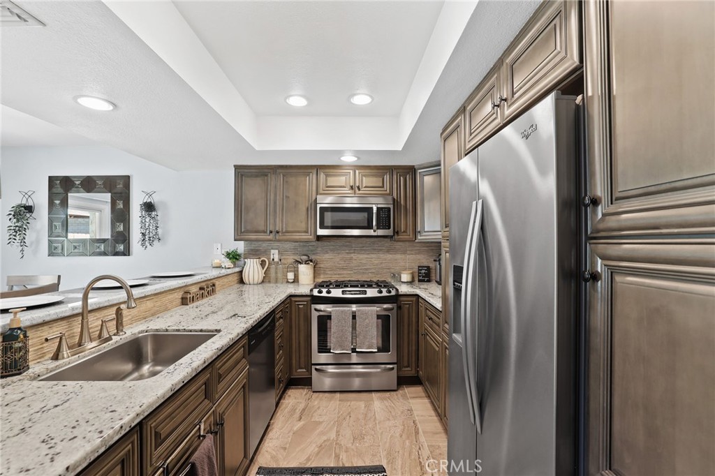 916 Ardmore Circle Redlands, CA 92374 - Photo 12 of 29 a kitchen with stainless steel appliances granite countertop a refrigerator a stove a sink a microwave and island
