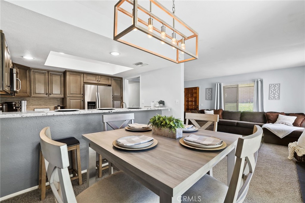 916 Ardmore Circle Redlands, CA 92374 - Photo 8 of 29 a view of a dining room and livingroom with furniture wooden floor a rug a painting and a chandelier