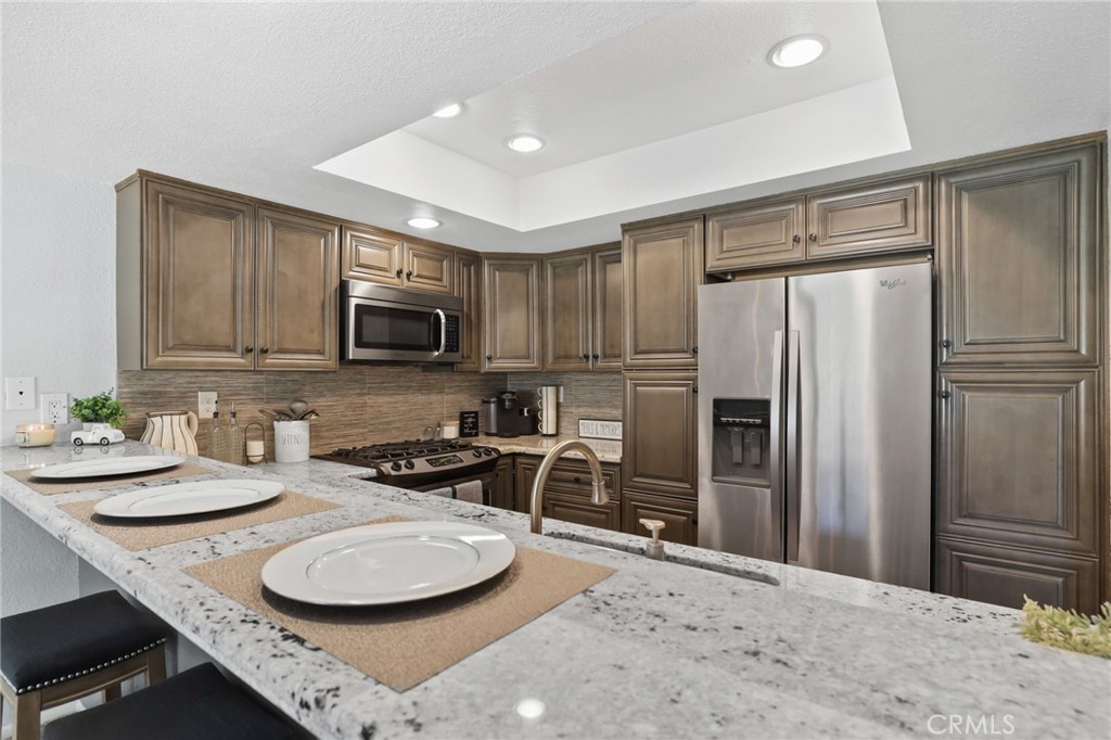 916 Ardmore Circle Redlands, CA 92374 - Photo 10 of 29 a kitchen with stainless steel appliances granite countertop a sink refrigerator and microwave