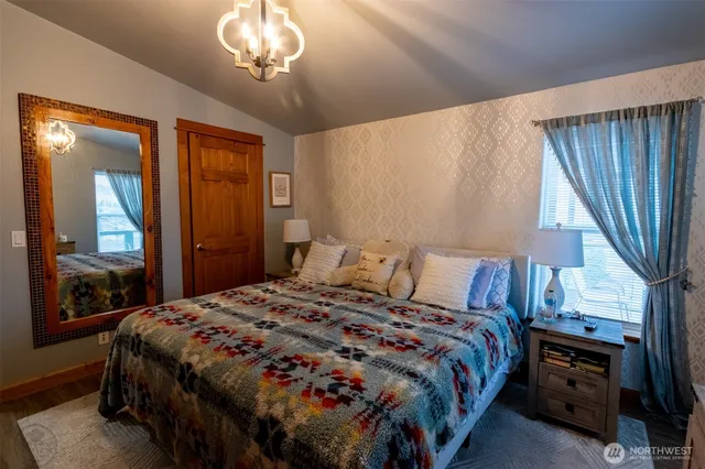 a bedroom with a bed and a chandelier