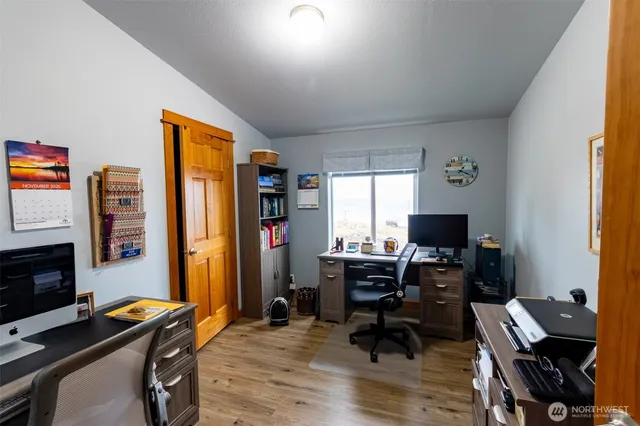 a view of a workspace with furniture and a window