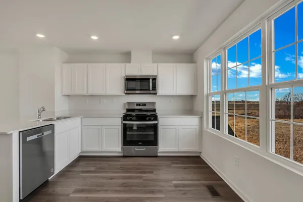 a kitchen with granite countertop a stove a sink and a refrigerator