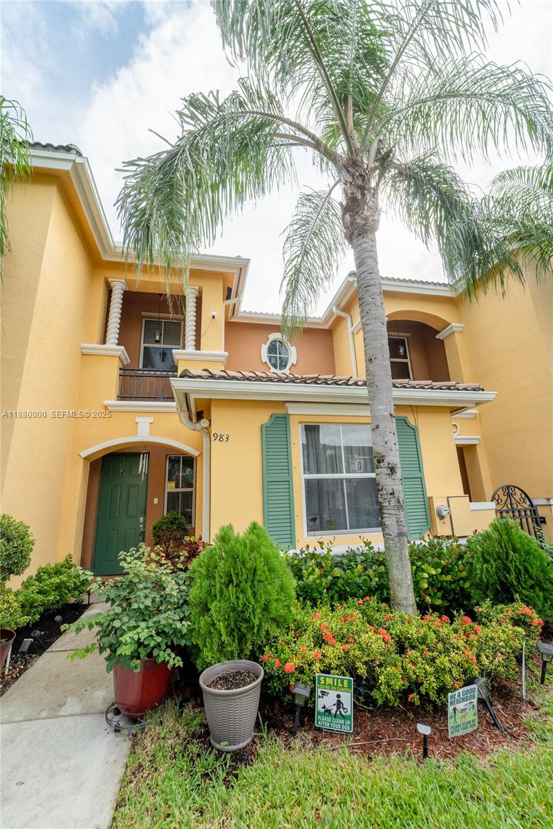 a front view of a house with a yard and potted plants