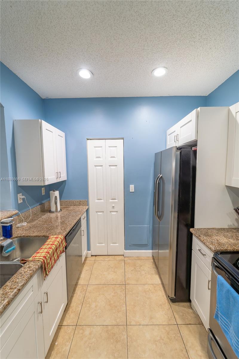 983 Northeast 42nd Place Homestead, FL 33033 - Photo 19 of 51 a kitchen with stainless steel appliances granite countertop a refrigerator and a sink