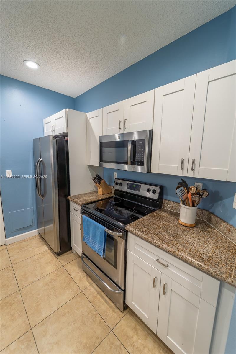 983 Northeast 42nd Place Homestead, FL 33033 - Photo 20 of 51 a kitchen with stainless steel appliances granite countertop a sink a stove a refrigerator a microwave and cabinets