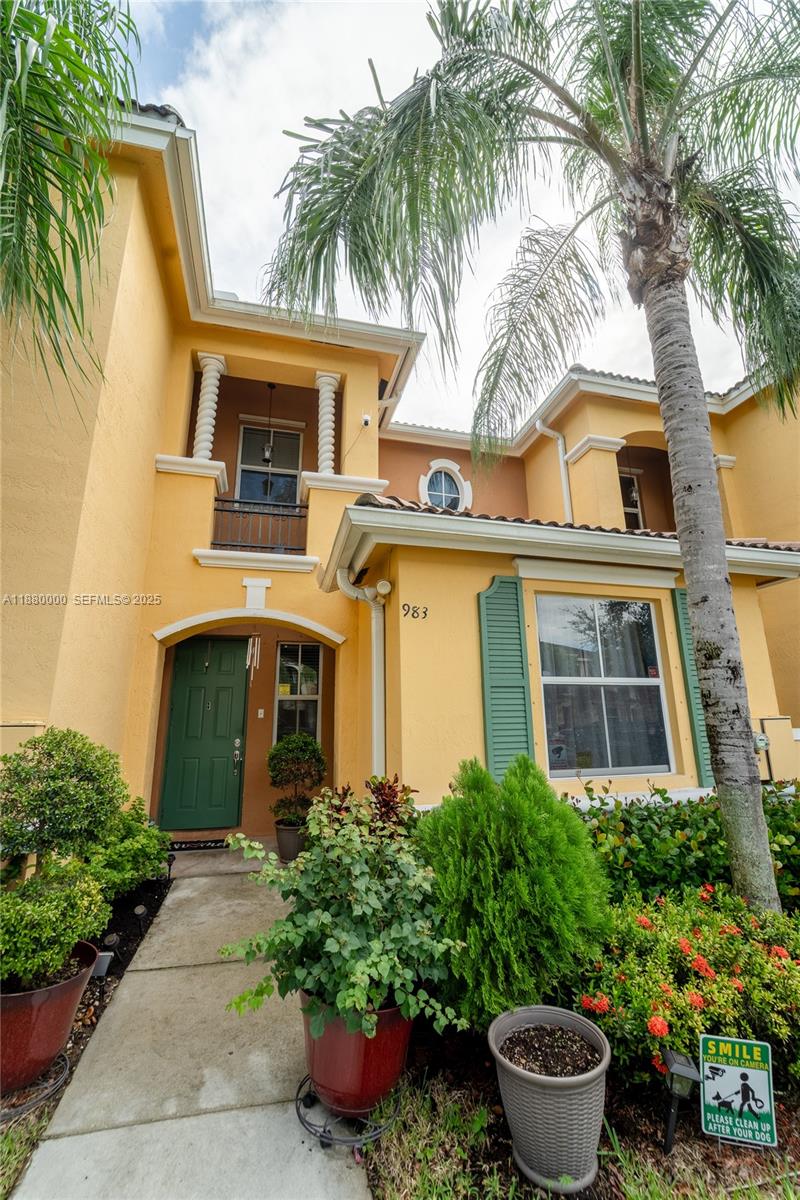 983 Northeast 42nd Place Homestead, FL 33033 - Photo 2 of 51 a front view of a house with a yard and potted plants