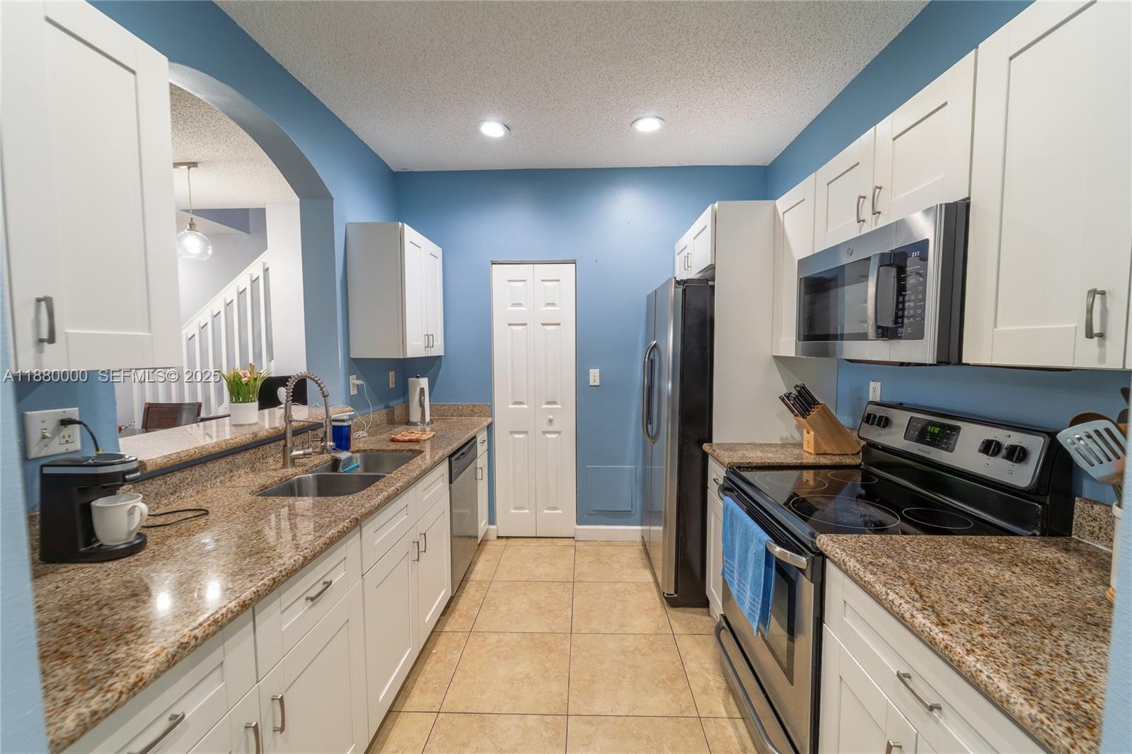 983 Northeast 42nd Place Homestead, FL 33033 - Photo 22 of 51 a large kitchen with stainless steel appliances granite countertop a sink stove and refrigerator