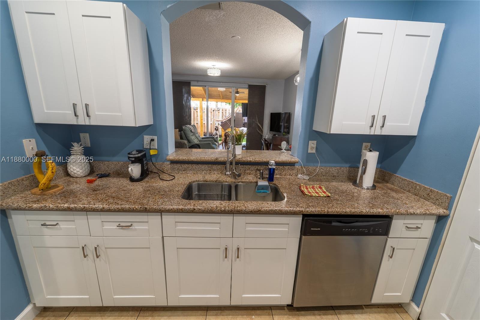 983 Northeast 42nd Place Homestead, FL 33033 - Photo 26 of 51 a kitchen with granite countertop a sink a stove and cabinets