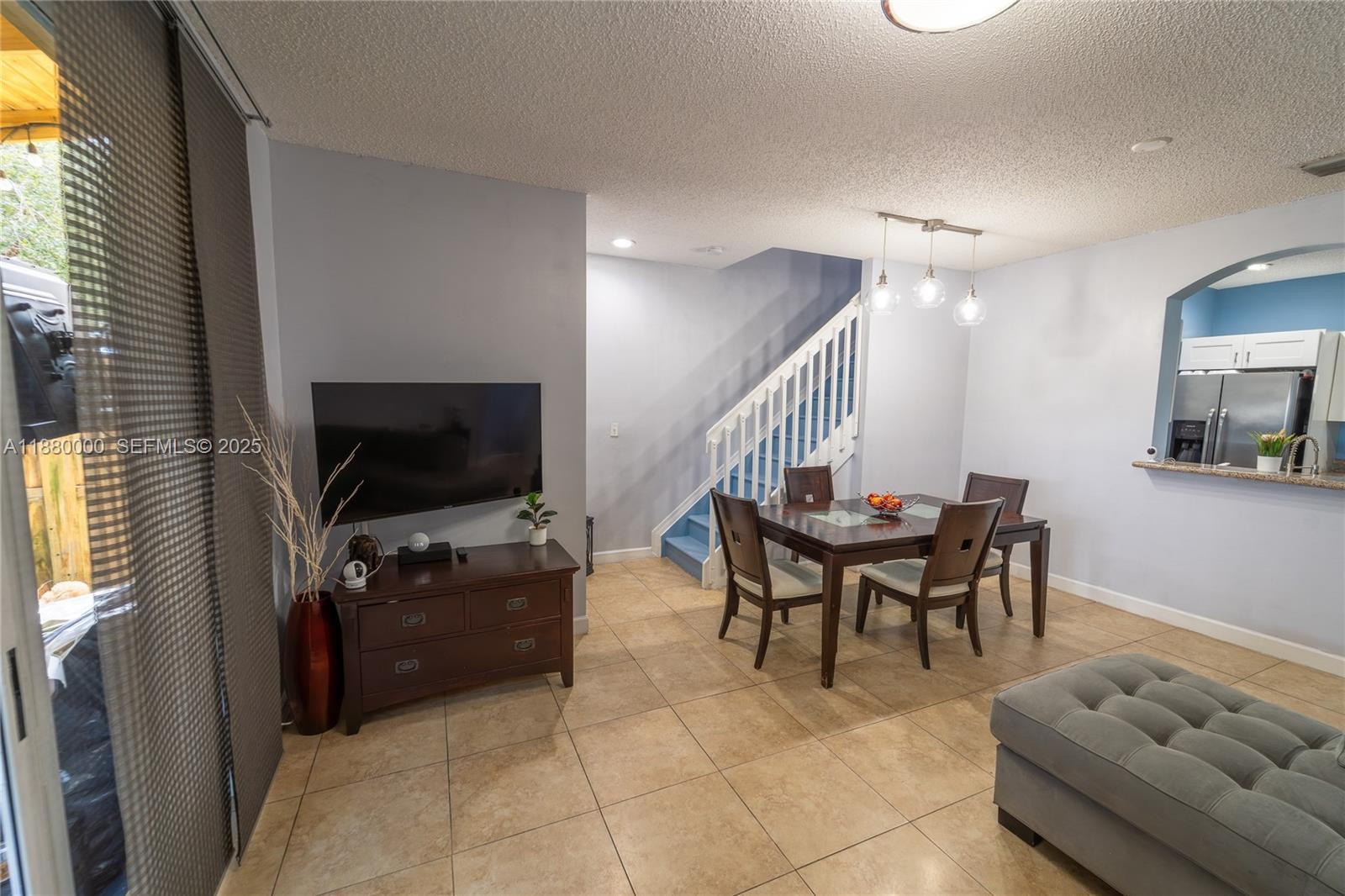 983 Northeast 42nd Place Homestead, FL 33033 - Photo 27 of 51 a dining room with furniture and a flat screen tv