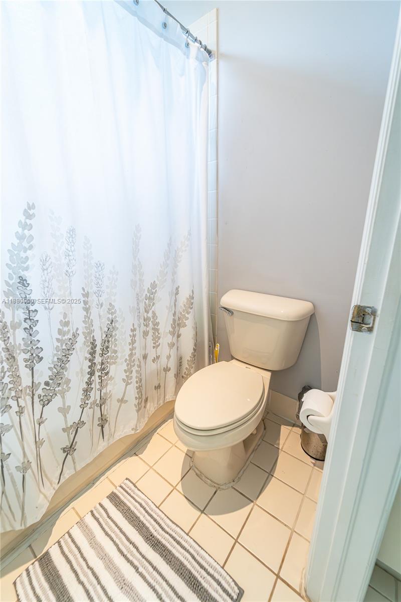 983 Northeast 42nd Place Homestead, FL 33033 - Photo 43 of 51 a white toilet sitting next to a shower curtain