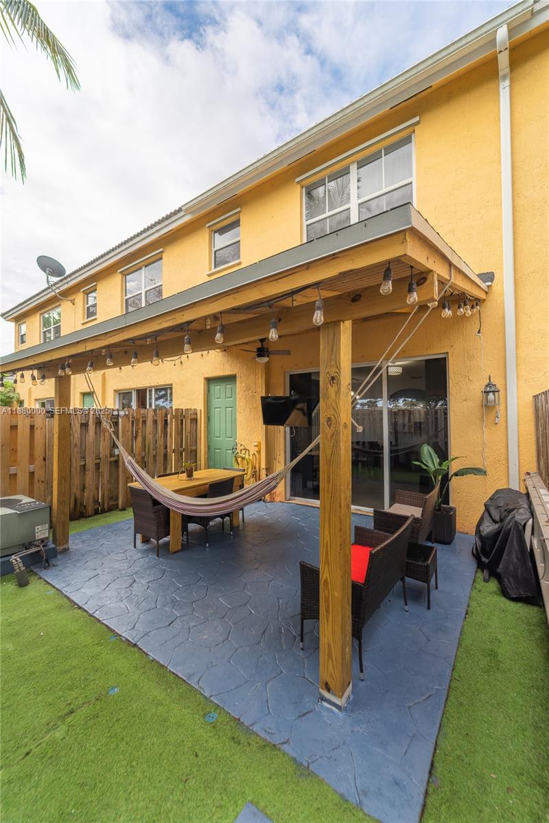 983 Northeast 42nd Place Homestead, FL 33033 - Photo 50 of 51 a view of a patio with table and chairs and potted plants