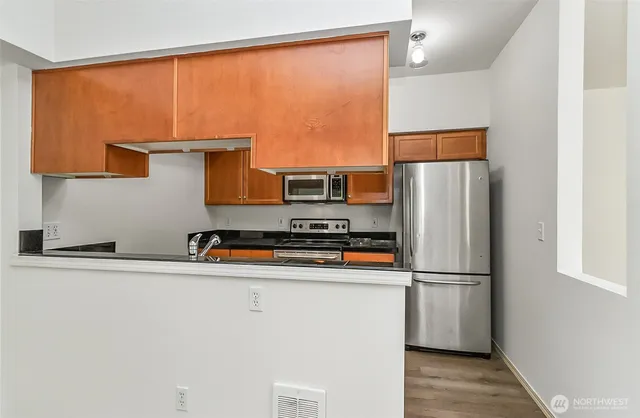 a kitchen with stainless steel appliances a refrigerator and a stove top oven