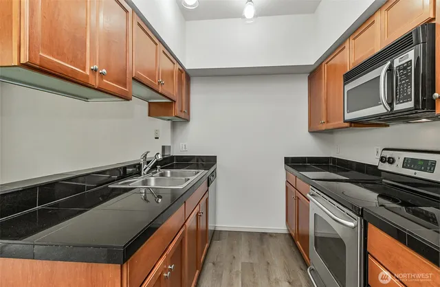 a kitchen with stainless steel appliances granite countertop a stove and a microwave