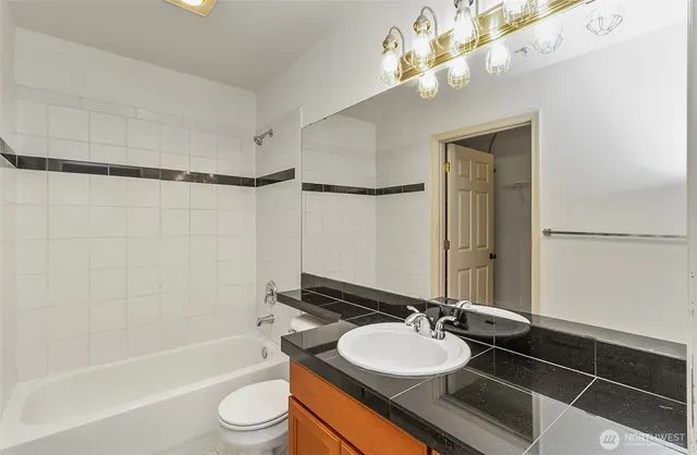 a bathroom with a sink a toilet a mirror and shower