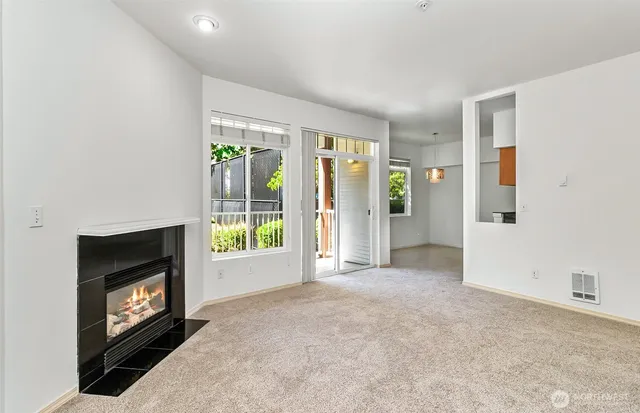a view of an empty room with furniture and a fireplace