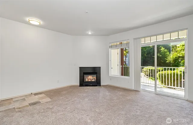 a view of an empty room with a fireplace and a window