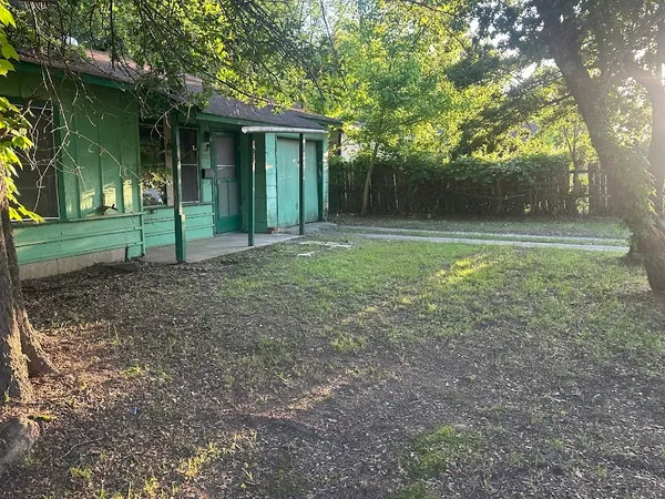 a view of a house with backyard and trees