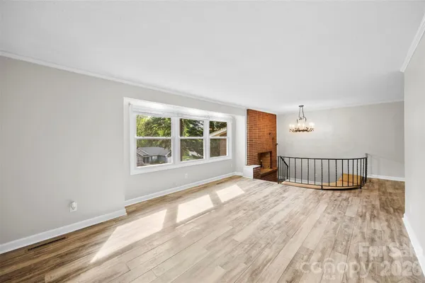 a view of a room with wooden floor and windows