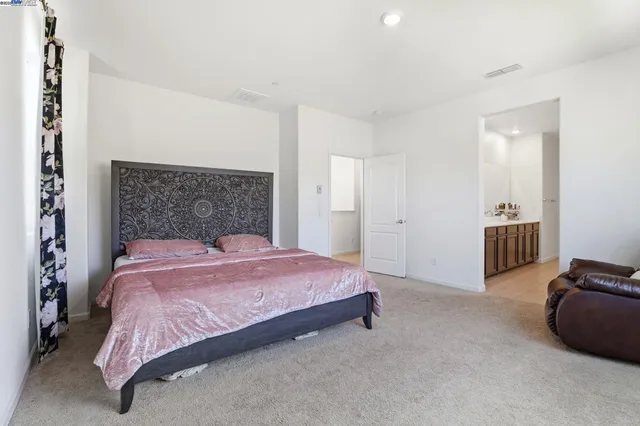 a bedroom with a bed and a lamp with the dresser