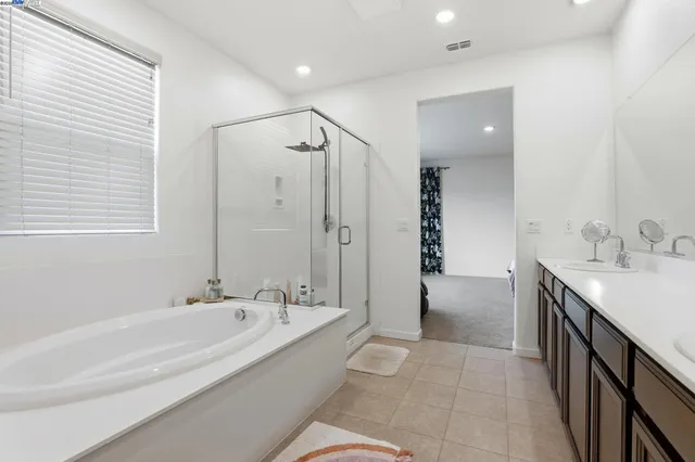 a spacious bathroom with a bathtub sink and mirror